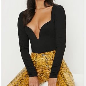 Deep plunge, black body suit.